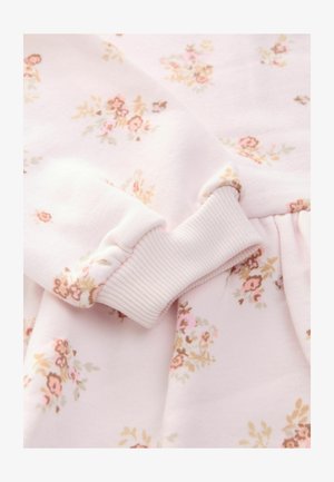 Roza cvetlična tkanina z rebrastimi manšetami. Ima majhne cvetove v roza in bež odtenkih na mehkem roza ozadju. Gladka tekstura.