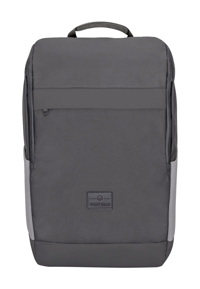 Sac à dos gris avec une finition en tissu lisse, comportant une poche zippée à l'avant, des poches latérales et un patch logo en bas. Poignée plate incluse.