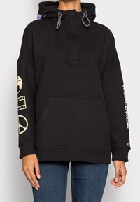 Zwarte pullover hoodie van katoen, met een voorszak, capuchon met trekkoord en bedrukte details op de mouwen en borst.