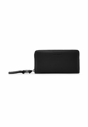 Cartera negra de cuero con cremallera alrededor, correa de muñeca y anillos plateados, con la marca "Fred'sbruder" en el centro frontal.