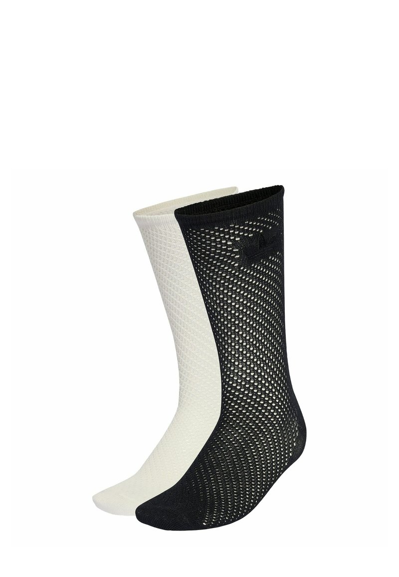 Pár ponožiek s sieťovaným vzorom, jedna čierna a jedna biela, zobrazené vedľa seba na bielom pozadí.