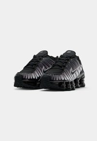 As sapatilhas Nike pretas apresentam um topo em malha com um design em gradiente, detalhes em borracha e uma sola distinta almofadada com molas.