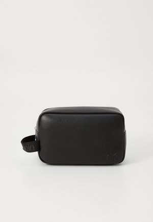 Black leather toiletry bag with a rectangular shape, textured surface, zipper closure, and a side handle featuring a logo accent.