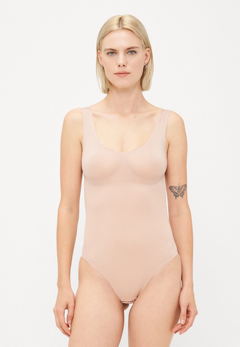 Nude-kleurige bodysuit met een ronde halslijn en brede bandjes, gemaakt van een gladde, rekbare stof. Heeft een eenvoudig ontwerp zonder versieringen.
