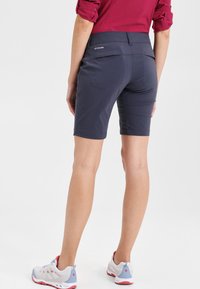 Pantaloni corti blu navy realizzati in un materiale leggero, con un design elegante, lunghezza a metà coscia e tasca posteriore con un accento del logo.