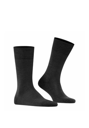 Pair of plain black mid-calf socks, one standing upright and the other angled to show heel and toe details on a white background.