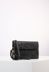 Kabelka s texturou černého hada, se zaklapávacím uzávěrem, zlatými kovovými detaily a odnímatelným popruhem. Kompaktní obdélníkový tvar.