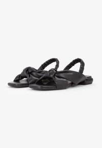 Zwarte platte sandalen van zacht leer met een geknoopt accent op de band en een rekbare, gerimpelde hak voor comfort.