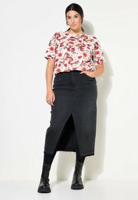 Wit top met bloemenpatroon en korte mouwen, gecombineerd met een zwarte denim maxi rok met een split aan de voorkant en zwarte enkellaarsjes.