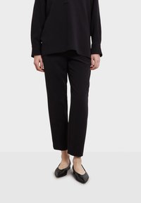 Zwarte, relaxte broek van zachte stof met een elastische tailleband; gladde textuur en recht gesneden pijpen.