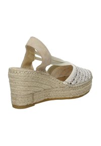 Sandalo con zeppa in beige con tomaia in tessuto intrecciato, cinturini elasticizzati e dettagli in juta. Presenta una suola testurizzata per aderenza e supporto.