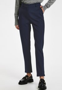 Tumši zila piegrieztā bikses no gludas auduma ar taisnu kāju dizainu, ar priekšējo pogas aizdari un sarullētām piedurknēm.