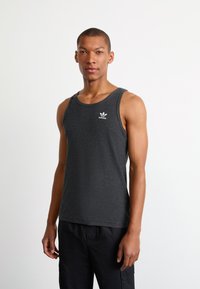 Grijze geribde tanktop met een ronde halslijn en brede schouderbanden. Beschikt over een klein wit Adidas-logo op de borst.