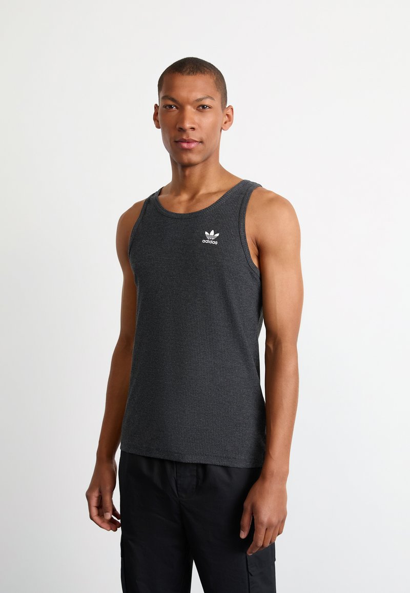 Grijze geribde tanktop met een ronde halslijn en brede schouderbanden. Beschikt over een klein wit Adidas-logo op de borst.