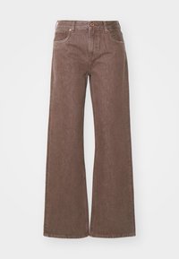 Barna, bő szárú farmernadrág, gombos záródással, két elülső zsebbels és texturált felülettel, amelyen finom színeltérések találhatók.