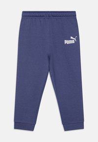 Tumši zili treniņbikšu no mīkstas auduma, ar elastīgu jostasvietu, ribotām aprocēm un baltu Puma logo uz kreisās kājas.