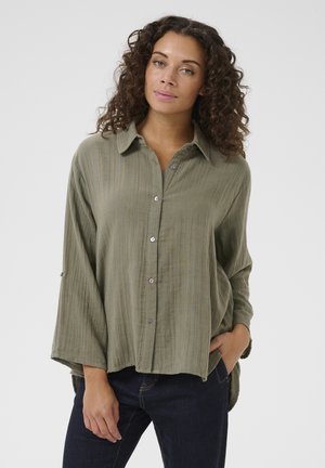 Olijfgroene, knoopsluiting shirt met kraag, lange mouwen en een relaxte pasvorm. Geweven stof met subtiele strepen en paarse knopen.