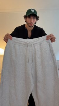 Light gray sweatpants with a drawstring waistband, featuring a smooth, soft texture and elastic cuffs at the ankles.