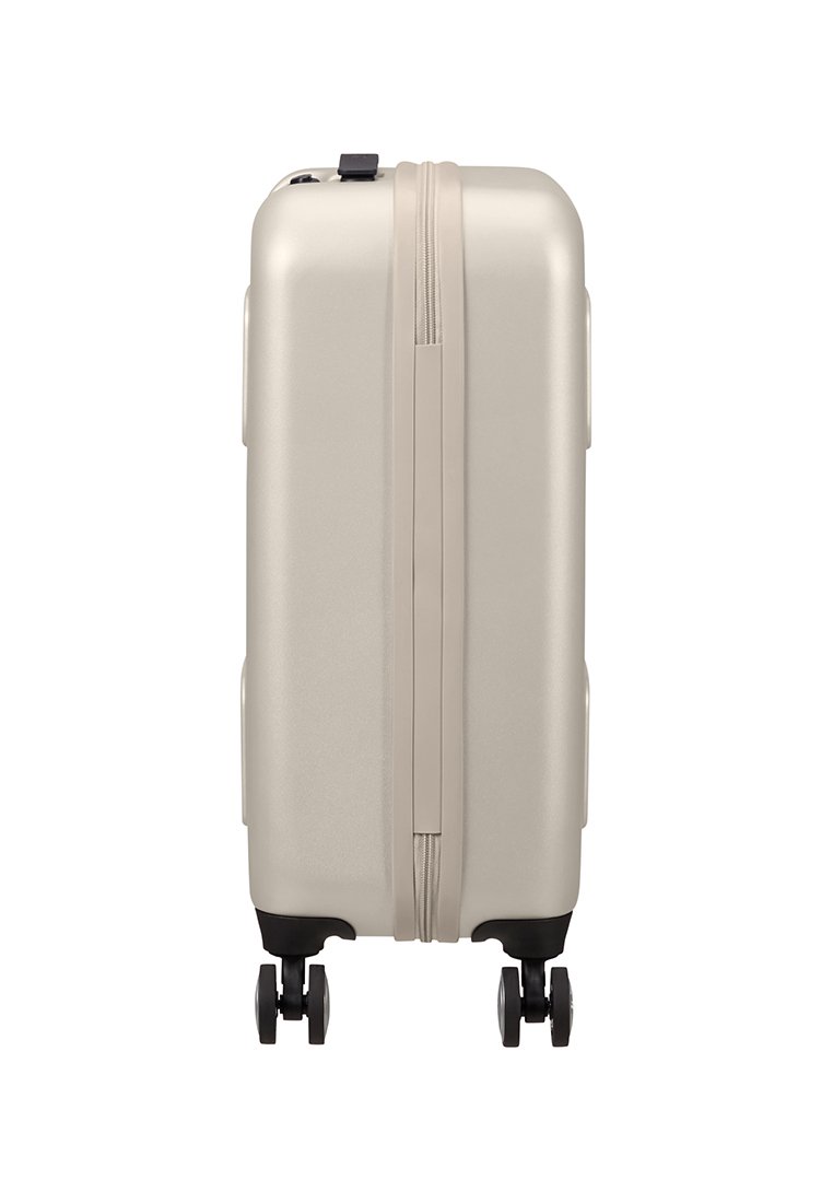 Valise rigide de couleur beige muted, avec une fermeture éclair, des poignées latérales et quatre roues noires pour une maniabilité aisée.
