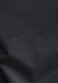 Black fabric with a smooth texture, featuring a horizontal seam near the top. The design is minimalist and uniform in color.