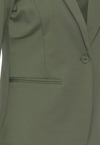 Blazer ajusté vert olive avec une fermeture à un bouton et une poche horizontale à fente sur le côté gauche.