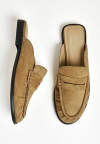 Barna suede slip-on loaferek, puha textúrával, fekete gumitalppal és díszvarrással a lábfej részen és a lábnyílás körül.