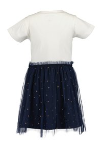 Haut blanc à manches courtes attaché à une jupe en tulle bleu marine avec de petits motifs de cœurs dorés, conçu comme une robe unique.