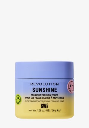 Poudre éclatante baptisée "Revolution Sunshine" pour les teints légèrement bronzés, présentée dans un récipient jaune et violet orné d'autocollants souriants.