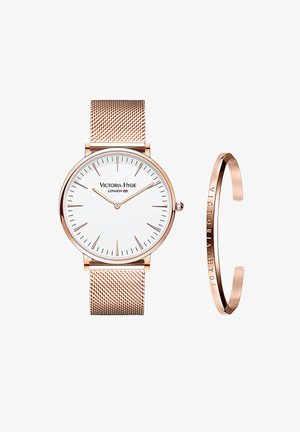 Runder weißer Ziffernblatt-Uhr mit roségoldenem Mesh-Armband, das minimalistische Markierungen und ein passendes roségoldenes Armreif mit Schriftzug zeigt.