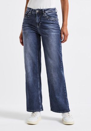 Jeans de mezclilla de pierna ancha en azul oscuro, con Remaches decorativos en los bolsillos frontales y un diseño clásico de cinco bolsillos.