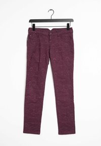 Burgundy denimbyxor med ett texturerat blommönster, utrustade med fem fickor och en knappstängning, hängande på en svart krok.