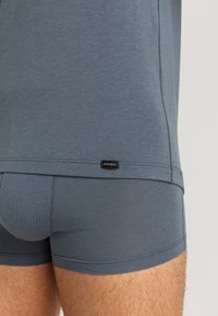 Mörkblå kalsonger och matchande t-shirt i mjuk, stretchig tyg. Har rena sömmar och en liten etikett på midjebandet.