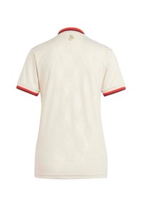 Polo crème avec motif en losange, doté d'un col et de poignets rayés rouge et orange. Logo doré au dos. Manches courtes.