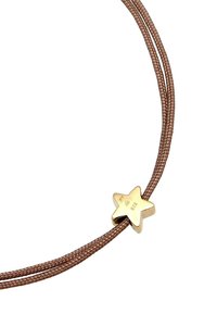 Bracelet avec un cordon tressé marron et un accent en forme d'étoile dorée avec des détails gravés. Design simple avec des lignes épurées.
