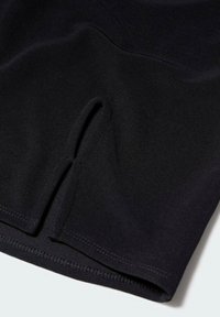 Tissu noir extensible avec un détail découpé au bord inférieur. Texture lisse et ourlet cousu. Design général élégant et minimaliste.