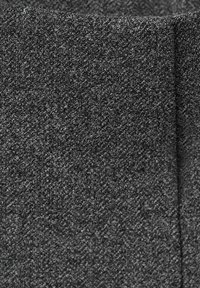 Grått tyg med en texturerad yta, som har en blandning av mörka och ljusa fibrer. Designen är slät med en subtil glans.