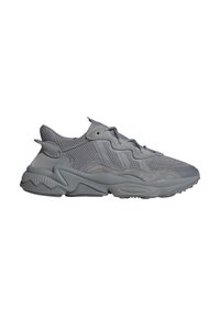 Scarpe da ginnastica grigie realizzate con materiali in rete e suede. Presentano una suola testurizzata, un design con lacci e una forma ergonomica. Vista laterale mostrata.