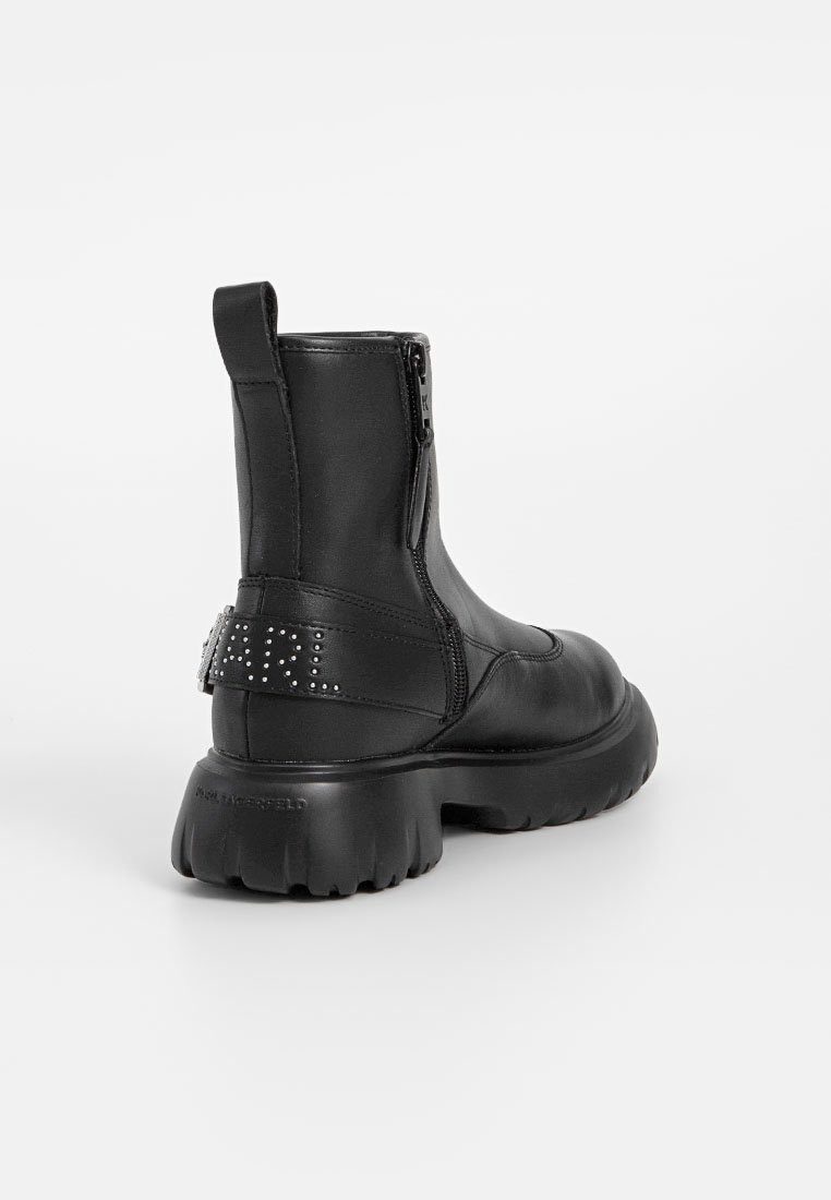 Schwarze Knöchelstiefel aus glattem Leder, mit einem seitlichen Reißverschluss, robuster Sohle und dekorativem Strassriemen auf der Rückseite.