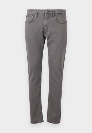 Szürke farmernadrág karcsú szabással, elülső zsebekkel, kontrasztos varrással és fémgombos zárással a deréknál.