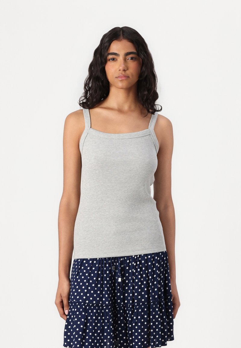 Top in cotone grigio a costine con spalline larghe e scollatura quadrata, abbinato a una gonna blu navy con pois bianchi e orlo arricciato.