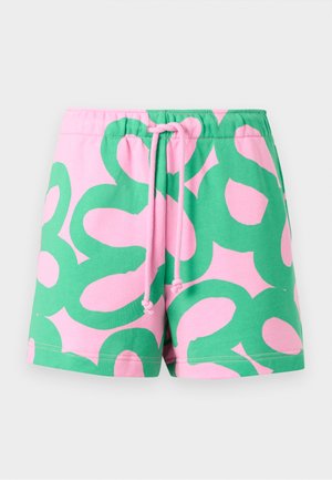 Lyserøde shorts med store grønne abstrakte blomsterprint og pink snøre i elastik i taljen på hvid baggrund.