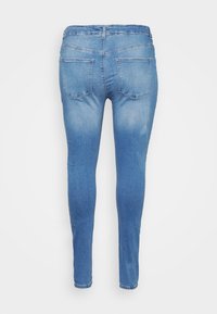 Smala jeans i ljusblå denim, med en blekt tvätt, två bakfickor och en smal passform som smalnar av mot vristerna.