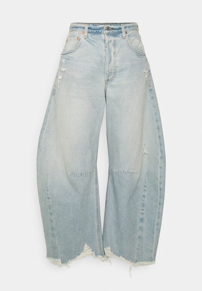 Jeans a gamba larga blu chiaro con lavaggio sbiadito, dettagli strappati e orlo sfrangiato. Presentano tasche frontali e una chiusura con bottone classica.