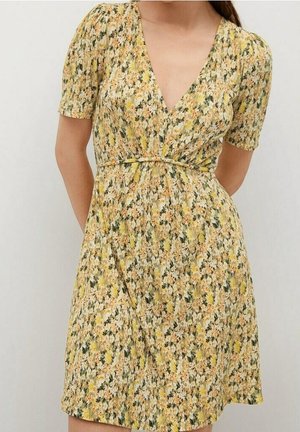 Floral dress in yellow and green with short puff sleeves, v-neckline, and gathered waist. Features a textured pattern of small flowers.