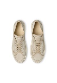 Sneakers in suede beige con punta arrotondata, lacci tono su tono e dettagli perforati. Presentano un collare imbottito e una suola in gomma.