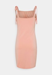 Brzoskwiniowa sukienka na ramiączkach z regulowanymi paskami na ramionach, gładka tkanina, dopasowany krój oraz zgromadzona elastyczna część z tyłu dla większego komfortu.