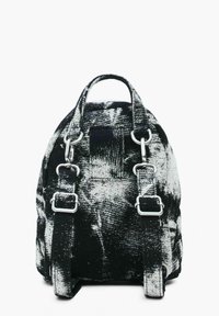 Rucsac cu un model alb-negru, fabricat din material textil. Dispune de două curele ajustabile și de accesorii metalice pentru închidere.
