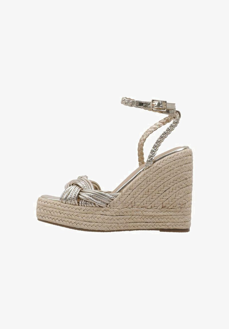 Sandale compensée beige avec plateforme en jute tressé, bandes métalliques tressées croisées sur les orteils et bride de cheville avec fermeture boucle dorée.