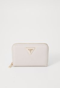 Beige strukturiertes Portemonnaie mit einer goldenen Guess-Logo-Plakette, Reißverschlussverschluss und einem kleinen Anhänger, das eine glatte und polierte Oberfläche aufweist.