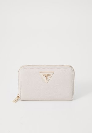 Carteira texturizada bege com uma placa do logótipo dourado da Guess, fecho com zip e uma pequena etiqueta em forma de pendente, apresentando uma superfície lisa e polida.
